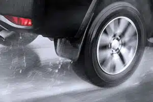 Close up of rear wheel of a car hydroplaning