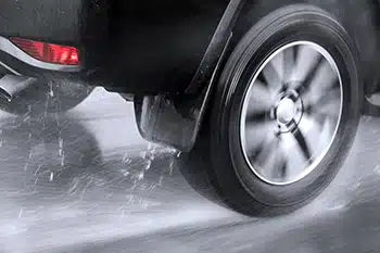 Close up of rear wheel of a car hydroplaning