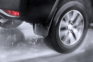 Close up of rear wheel of a car hydroplaning